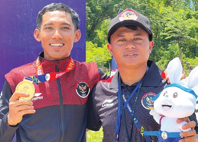 BERSAMA : Dwi Edi Kurniawan berfoto dengan atlet binaannya yang meraih emas di Sea Games Kamboja. (Dwi Edi Kurniawan for Radar Malang)