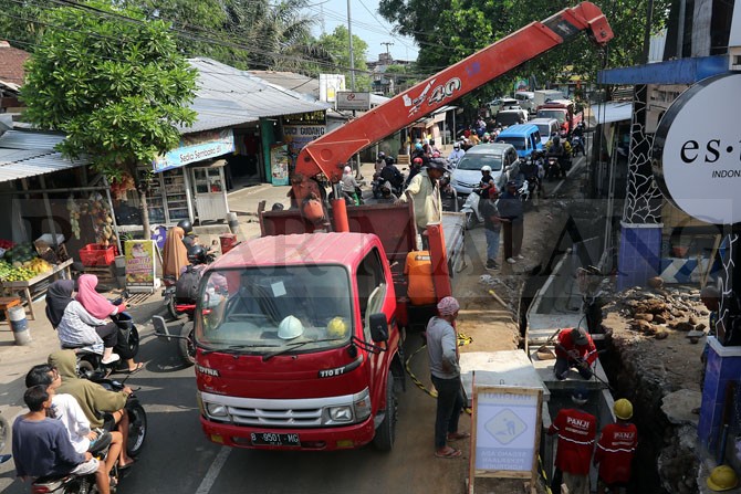 CEGAH BANJIR: Para pekerja menggunakan sebuah mobil crane untuk memasang beton u-ditch di saluran drainase baru di tepi Jalan Tebo Utara, Kelurahan Mulyorejo, Kecamatan Sukun, kemarin.(Darmono/Radar Malang)