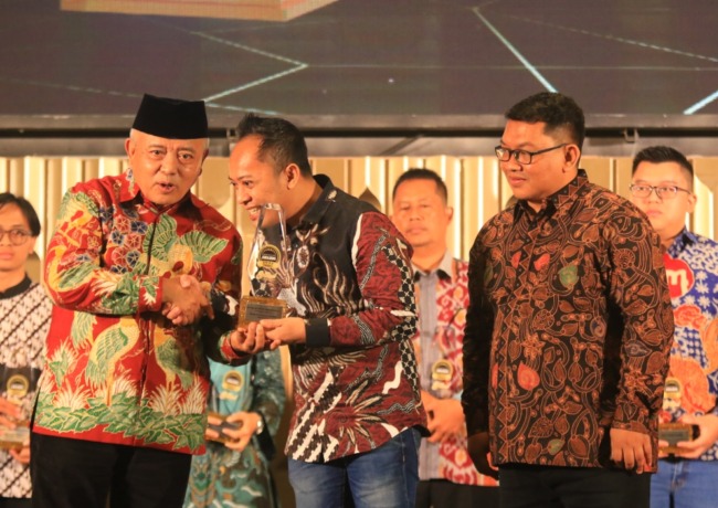 Bupati Malang H M Sanusi menyerahkan Radar Malang Award kepada Direktur PT RKM Dahlan Anwar Salam.