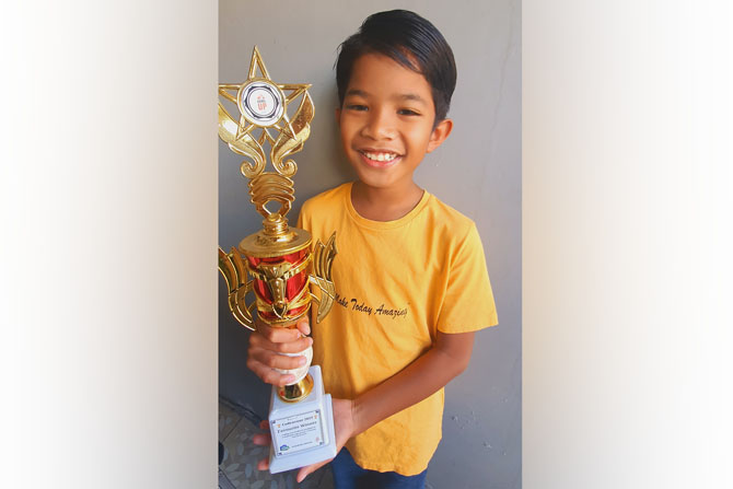 BERBAKAT: Kevin Veashna Athaa Sudewo menunjukkan piala juara favorit Coding and Artificial Intelligent Competition 2023.(FAJAR ANDRE/RADAR MALANG)