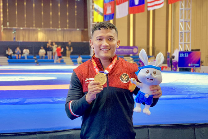 SANG JUARA: Lulut Gilang Saputra usai menerima medali emas Sea Games 2023 di Kamboja, 17 Mei lalu. (Lulut Gilang Saputra for Radar Malang)
