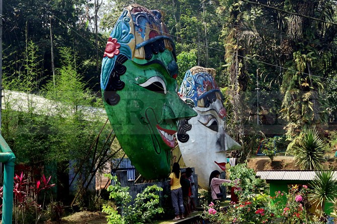 BANGKIT LAGI: Warga mengecat topeng raksasa di Kampung Topeng Malangan kemarin (21/5). Kampung wisata itu sempat vakum selama dua tahun akibat pandemi Covid-19. (Darmono/Radar Malang)