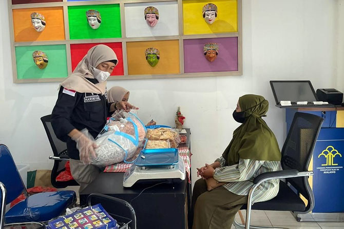 TAK DIBATASI: Petugas Lembaga Pemasyarakatan Perempuan (LPP) Kelas IIA Malang memeriksa makanan yang dibawa pembesuk pada momen kunjungan Lebaran.(HUMAS LPP MALANG FOR RADAR MALANG)