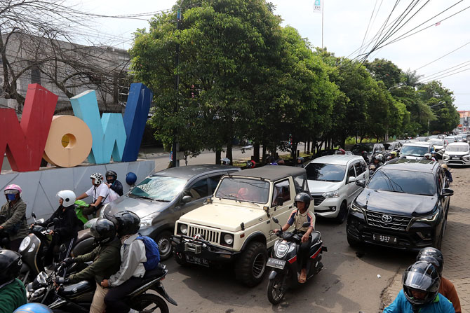 BANYAK WISATAWAN: Macet ratusan meter tersaji di Jalan Raya Sawojajar, kemarin siang (30/4). Penutupan exit tol Karanglo selama 30 menit menjadi salah satu penyebabnya.(Darmono / Radar Malang)