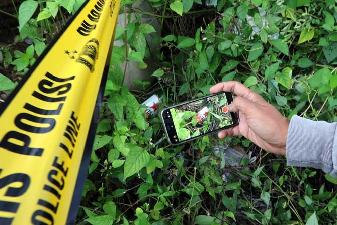 LOKASI : Botol bir ditemukan di lokasi pesta miras oplosan maut di Karangploso. (Darmono/Radar Malang)