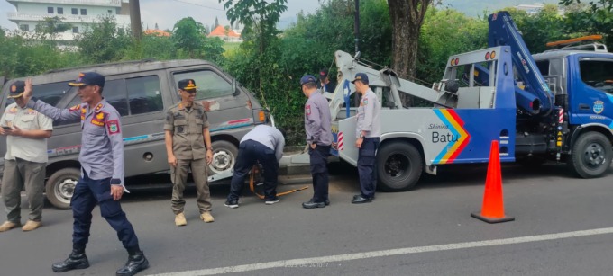 MELANGGAR: Salah satu mobil yang diparkir sembarangan diderek oleh petugas dari Dishub Kota Batu.