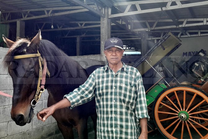 ANDALAN KOTA BATU: Sutikno bersama kuda piaraannya saat di rumahnya, Desa Pesanggrahan, Kecamatan Batu kemarin (15/5). (Afifah/Radar Malang)