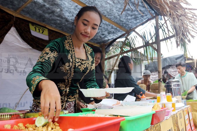 TEMPO DULU: Penjaga stan makanan tradisional mengenakan kebaya untuk memberikan kesan jadoel. (Darmono/Radar Malang)