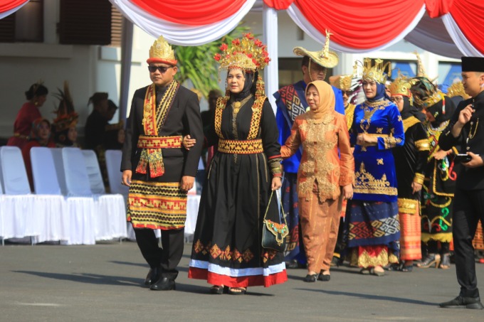 JAGA PERSATUAN: Kepala Bapenda Kota Malang Handi Priyanto bersama sang istri memakai baju adat Lampung ketika upacara Harlah Pancasila, kemarin pagi. (suharto/radar malang)