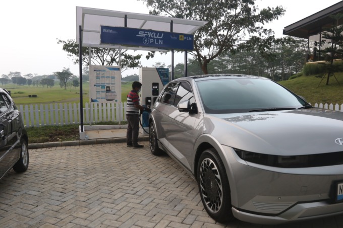 ISI DAYA BATERAI: Salah satu pemilik mobil listrik mengisi daya baterai kendaraannya di SPKLU Ombie Kofie Araya, kemarin siang. (darmono/radar malang)