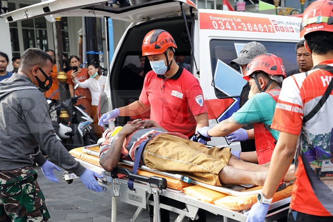 TABRAKAN : Seorang korban kecelakaan jalan protokol Kota Malang diangkut menuju ambulans. (Suharto/Radar Malang)