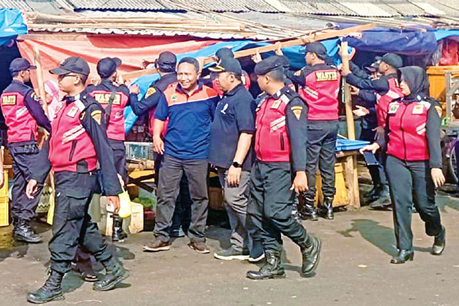 BAKAL RUTIN: Petugas Diskopindag dan Dishub Kota Malang menertibkan pedagang Pasar Induk Gadang yang menempatkan barang dagangan di atas badan jalan kemarin. (Dinas Perhubungan for Radar Malang)