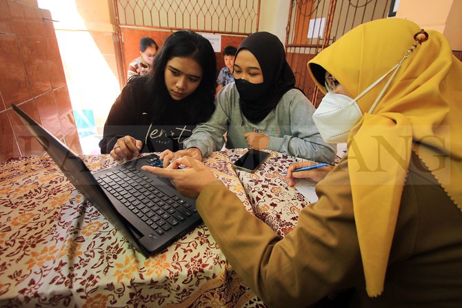 CEK : Calon siswa menerima informasi PPDB dari tenaga pendidik di satu sekolah di Kota Malang. (Suharto/Radar Malang)