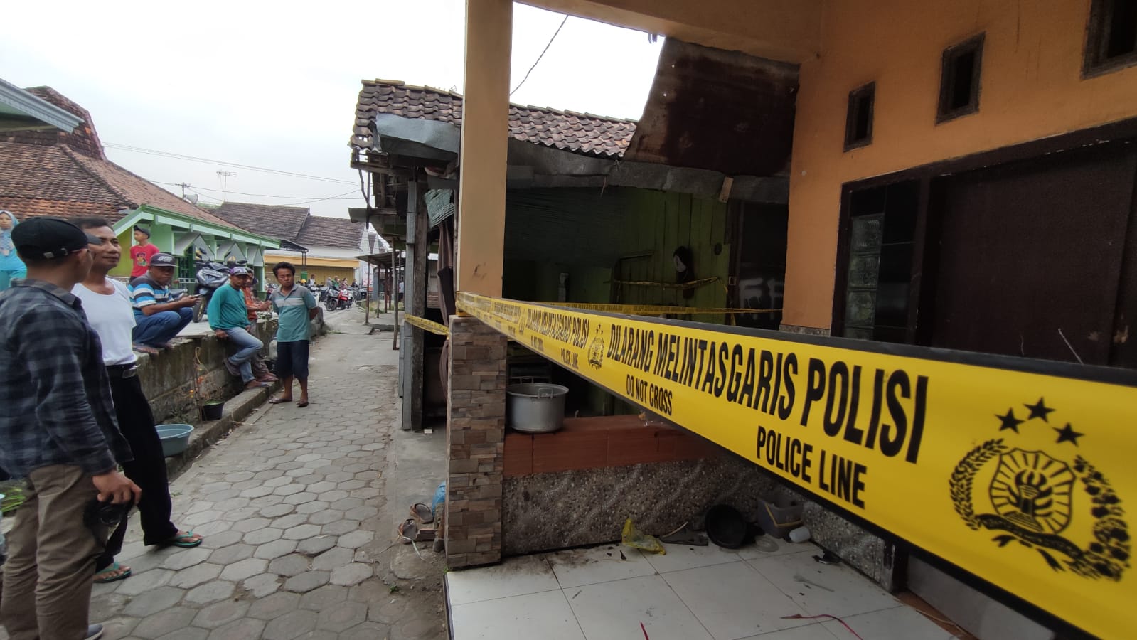 GARIS POLISI: Rumah pelaku di Kecamatan Kemlagi masih terbentang police line, Kamis (15/6).