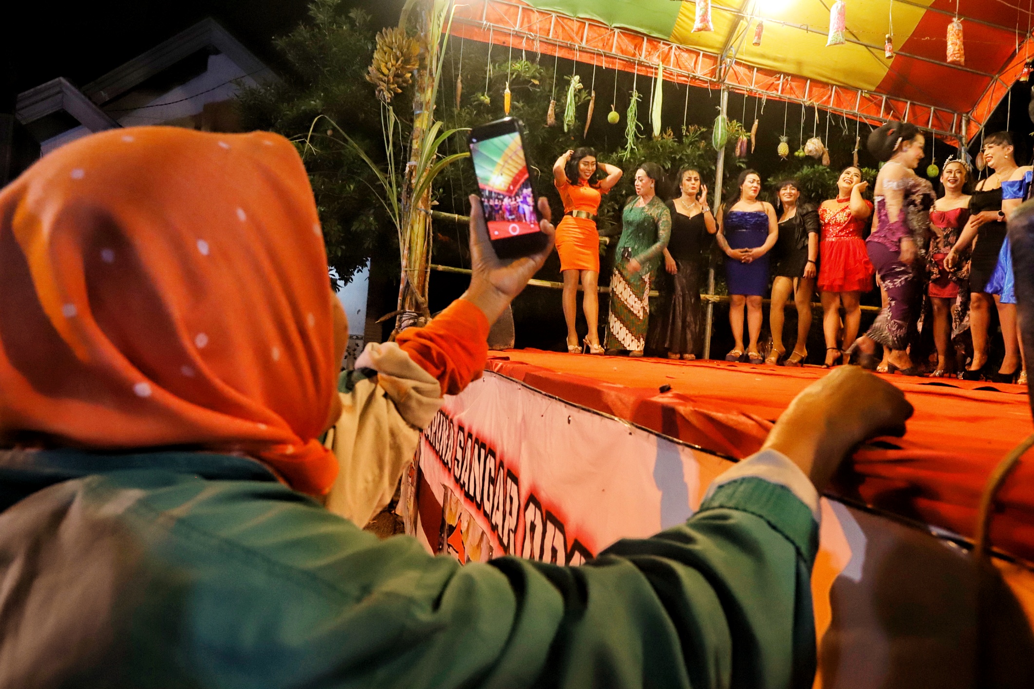ANTUSIAS: Seorang warga antusias mendokumentasikan para transvesti penampil pembuka kesenian ludruk.