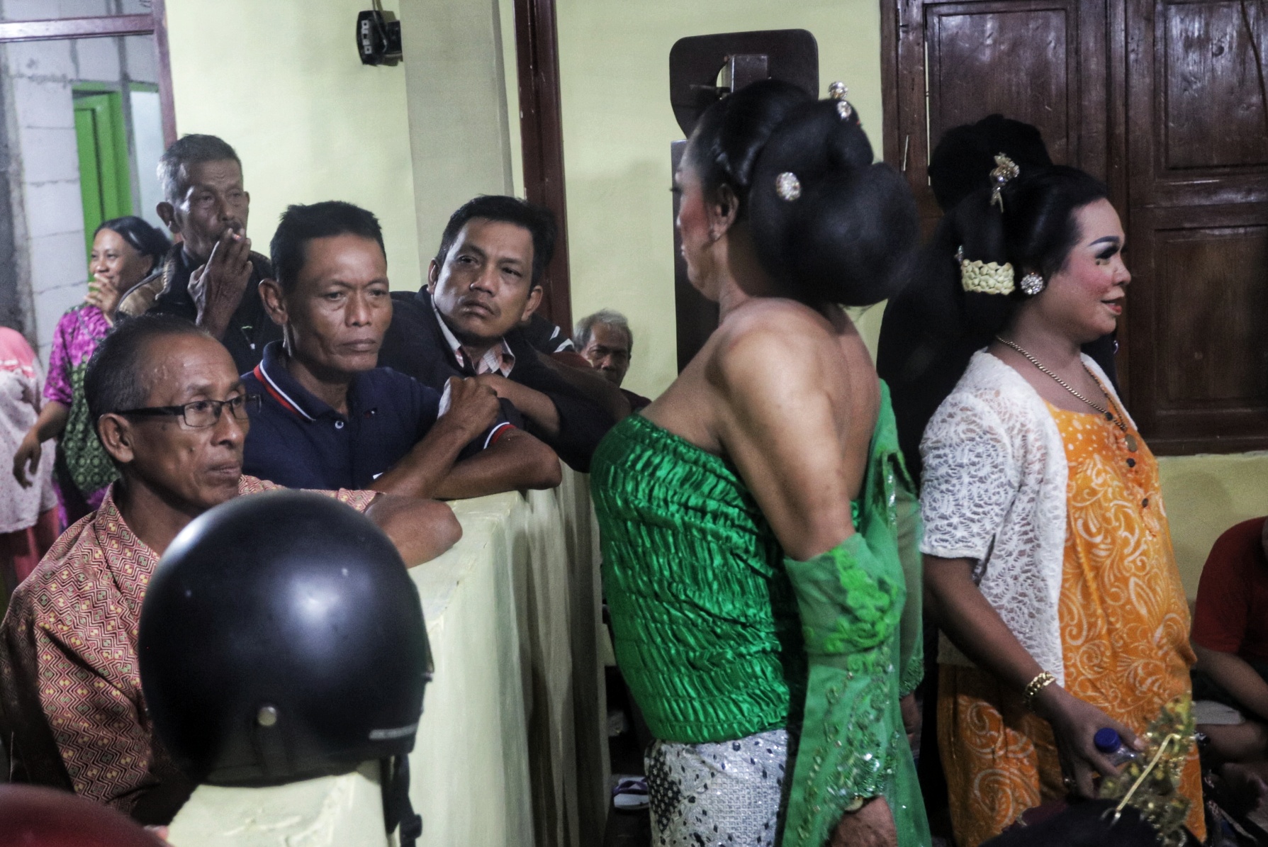 INTERAKSI: Warga setempat penasaran melihat para pemain ludruk dan tranvesti menata make up.