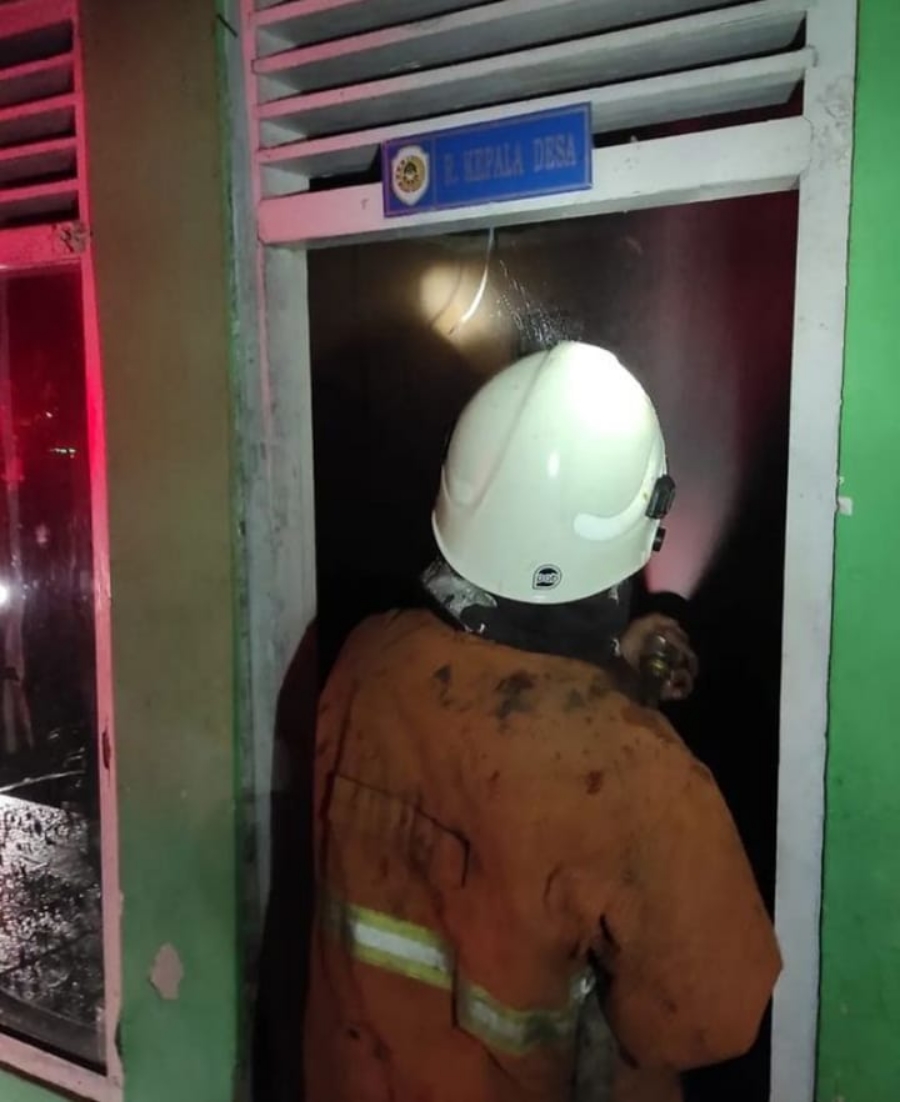 RUANG KADES: Petugas pemadam masuk ruang kantor kepala desa yang terbakar.