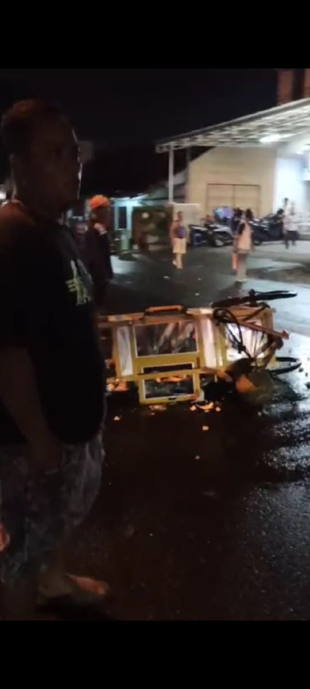 TUMPAH: Gerobak bakso milik Wiji dievakuasi warga usai ditabrak pengendara motor.