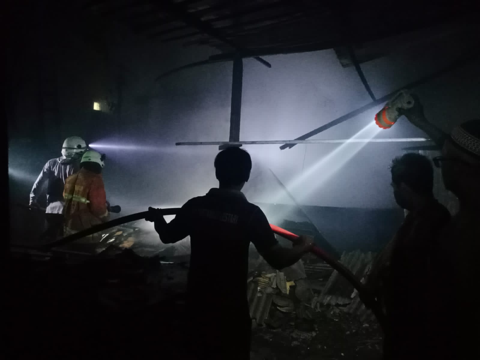PENANGANAN: Petugas berjibaku memadamkan kebakaran di home industri pembuatan box sound system di Dusun Jogodayoh, Desa Jabon, Kecamatan Mojoanyar, Kabupaten Mojokerto, Rabu (12/7) mal