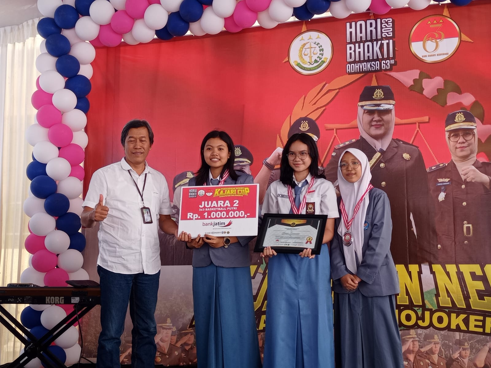 PENYERAHAN HADIAH: Direktur Jawa Pos Radar Mojokerto M. Nur Kholis (baju putih) menyerahkan hadiah kepada juara kedua lomba basket 3x3 kategori pelajar putri ajang Kajari Cup.