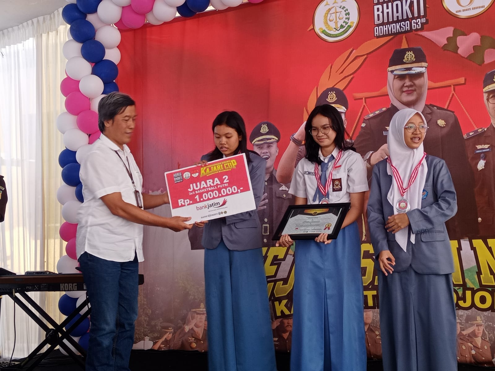 PENYERAHAN HADIAH: Direktur Jawa Pos Radar Mojokerto M. Nur Kholis (baju putih) menyerahkan hadiah kepada juara kedua lomba basket 3x3 kategori pelajar putri ajang Kajari Cup.