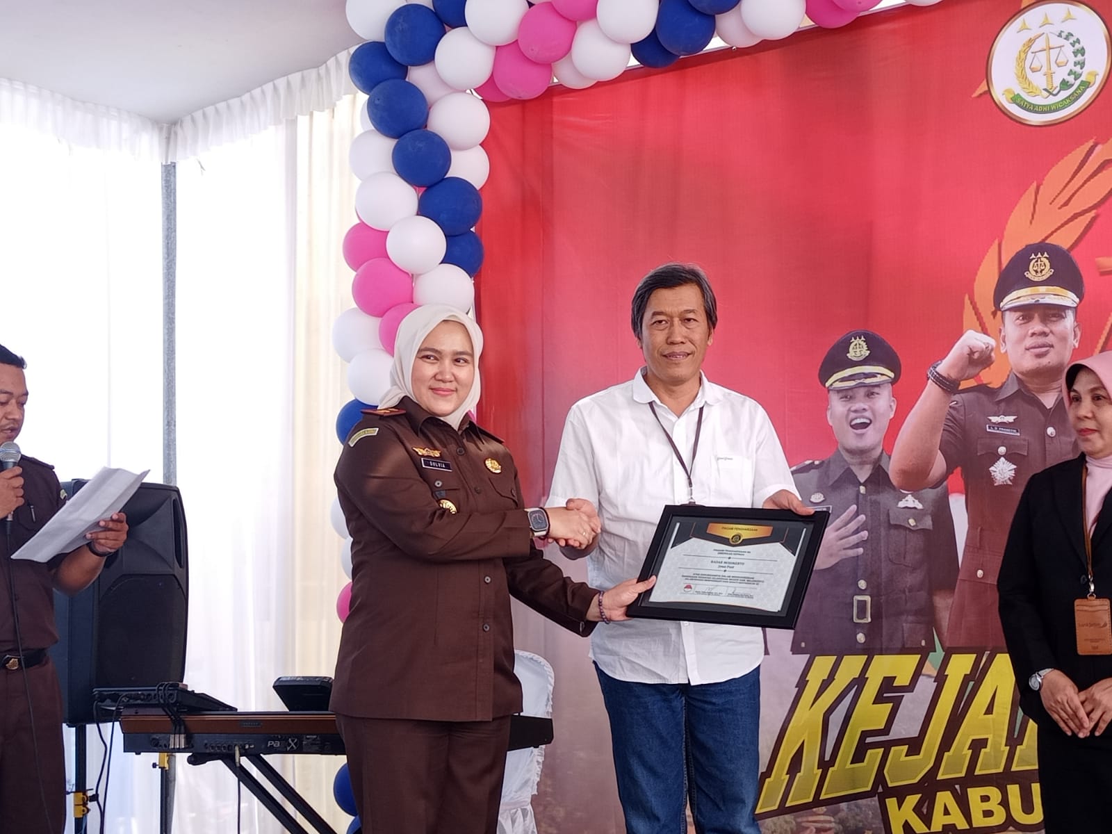 PENGHARGAAN: Direktur Jawa Pos Radar Mojokerto M. Nur Kholis (baju putih) menerima penghargaan dari Kajari Kabupaten Mojokerto Sulvia Triana Hapsari dalam penutupan peringatan HBA ke-63, Senin (24/7).