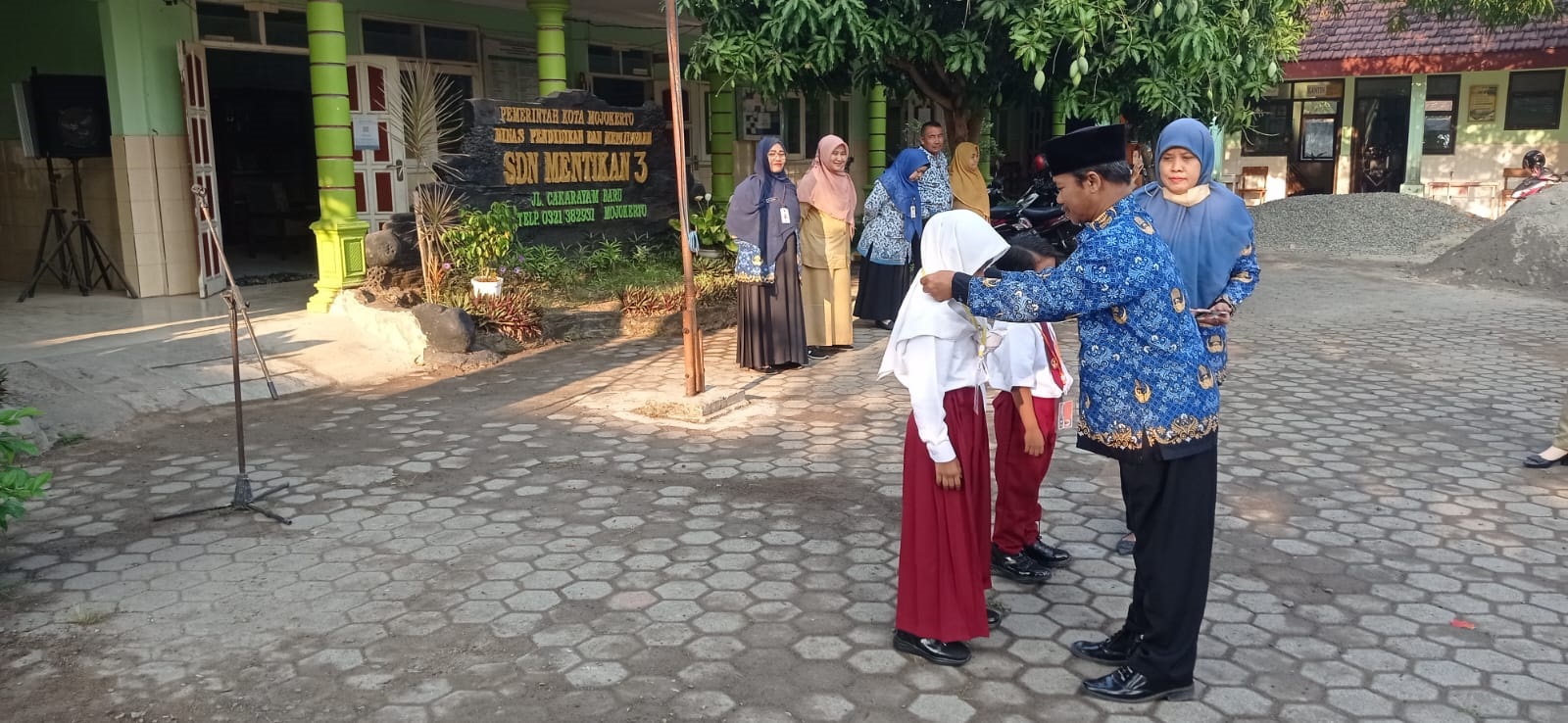 AKRAB: Kepala SDN Mentikan 3, Sodikin menyematkan tanda pengenal kepada siswa baru saat pembukaan MPLS, Senin (17/7).