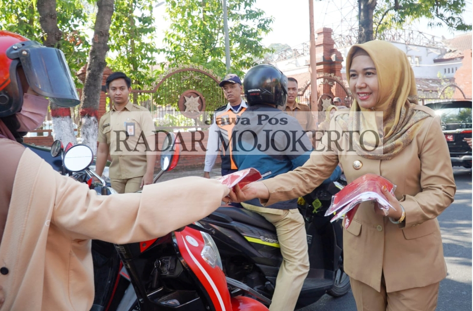 NASIONALISME: Wali Kota Mojokerto Ika Puspitasari membagikan bendera merah putih kepada warga di sekitar Alun-Alun Wiraraja menyambut HUT Ke-78 RI, Senin (31/7).