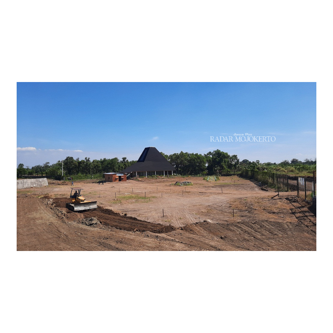 DIGULIRKAN: Pekerja meratakan tanah uruk dengan alat berat di lokasi proyek pembangunan Taman Bahari Mojopahit di kawasan Sungai Ngook, Kecamatan Prajurit Kulon, Kota Mojokerto.