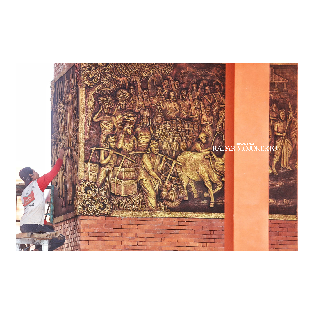 SENI RUPA: Pekerja proyek memasang relief di sisi tugu Alun-Alun Wiraraja yang menggambarkan tentang perjuangan kemerdekaan.