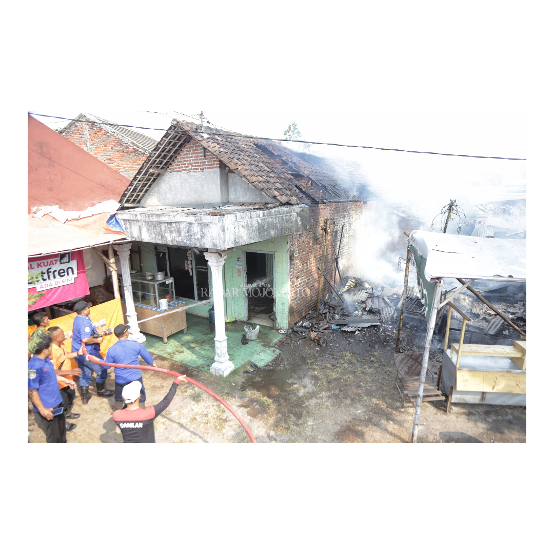 HANGUS: Petugas Damkar Kota Mojokerto menyemprotkan air ke kios dan rumah yang sengaja dibakar di Kelurahan/Kecamatan Prajurit Kulon kemarin.