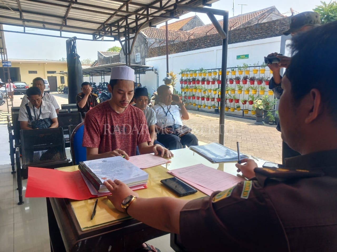 MENUNDUK: Kedua tersangka pembunuhan dengan racun di kos, Dusun Nambangan, Desa Ngimbangan, Kecamatan Mojosari, dilimpahkan ke Kejari Kabupaten Mojokerto, Selasa (15/8).