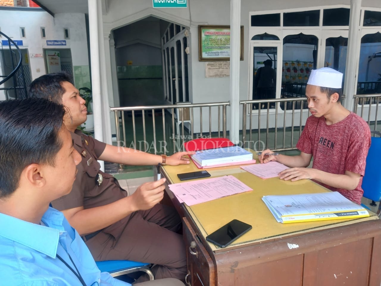 MENUNDUK: Kedua tersangka pembunuhan dengan racun di kos, Dusun Nambangan, Desa Ngimbangan, Kecamatan Mojosari, dilimpahkan ke Kejari Kabupaten Mojokerto, Selasa (15/8).