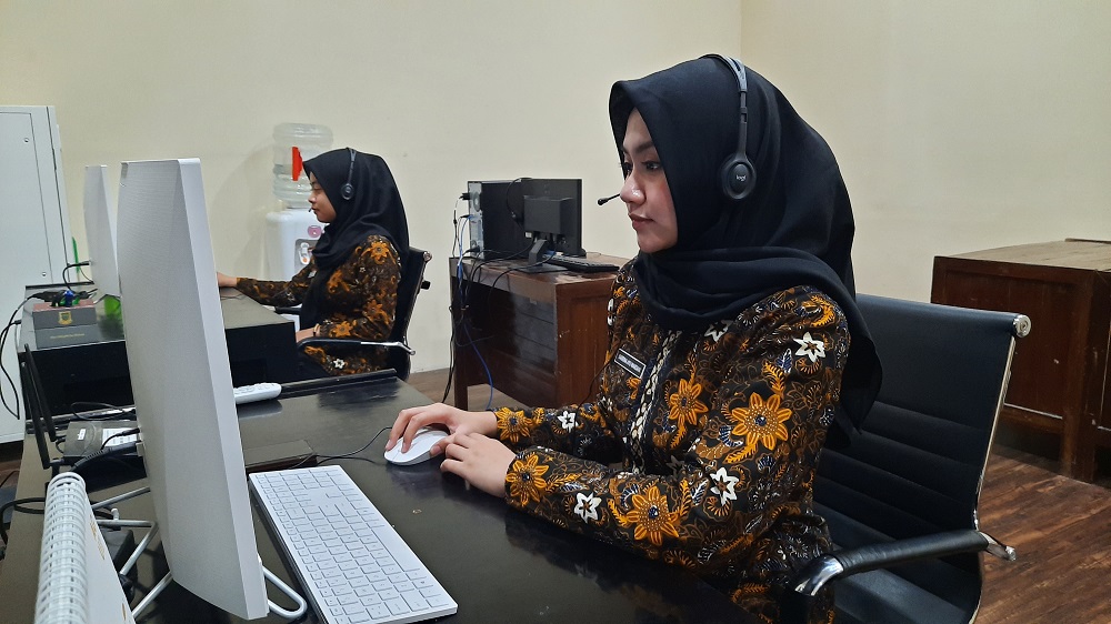 SIAGA: Sabrina Ayu Wardani dan Aldonna Sandra, petugas Call Center 112 Kota Mojokerto saat bersiaga di ruang operator di gedung Pemkot Mojokerto.