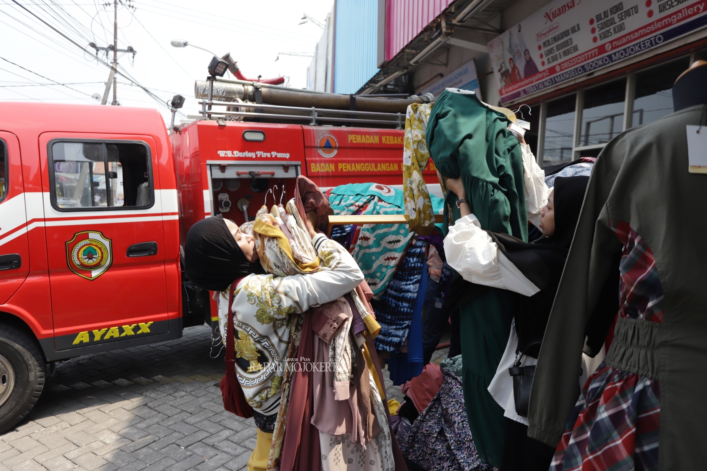 MENDADAK: Pegawai menyelamatkan busana keluar dari toko.