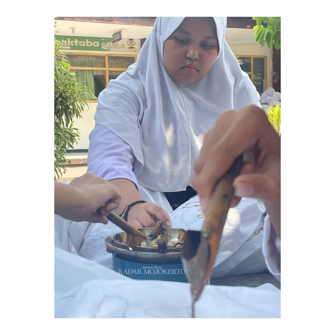 SENANG: Siswa SMPN 1 Mojokerto sedang proses mencanting kain batik yang telah diberi pola.