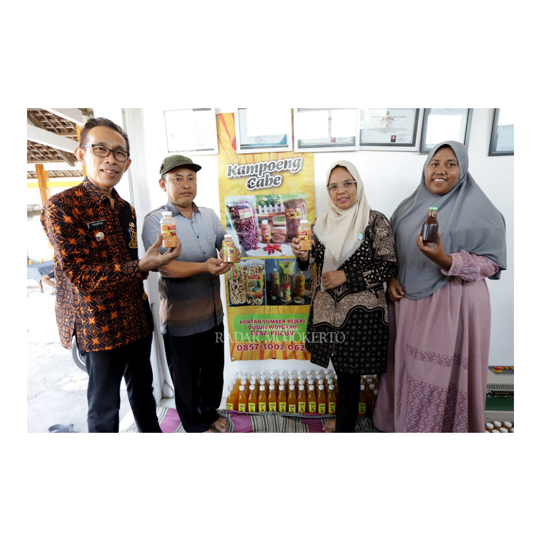 KAYA INOVASI: Kepala Desa Pucuk Nanang Sudarmawan (pakai topi) bersama Camat Dawarblandong Taufiq (kiri) menunjukkan produk olahan cabai khas Desa Pucuk.