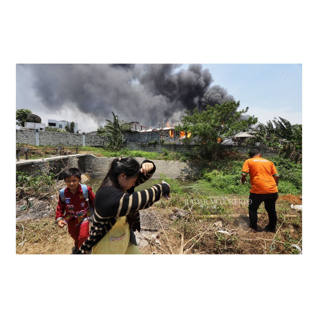 TERBAKAR HEBAT: Warga melintas di area kebakaran pabrik tisu di Desa Sukoanyar, Kecamatan Ngoro Mojokerto,  Kamis (12/10)
