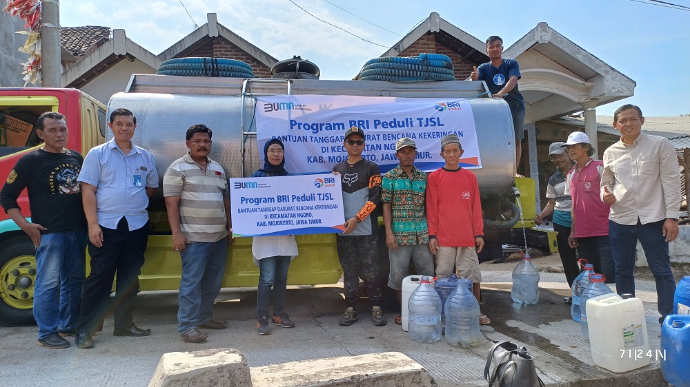 TITIK KEDUA: Staf BRI Cabang Mojokerto dan perangkat Desa Manduro ikut secara simbolis menyalurkan air bersih di titik yang berbeda.