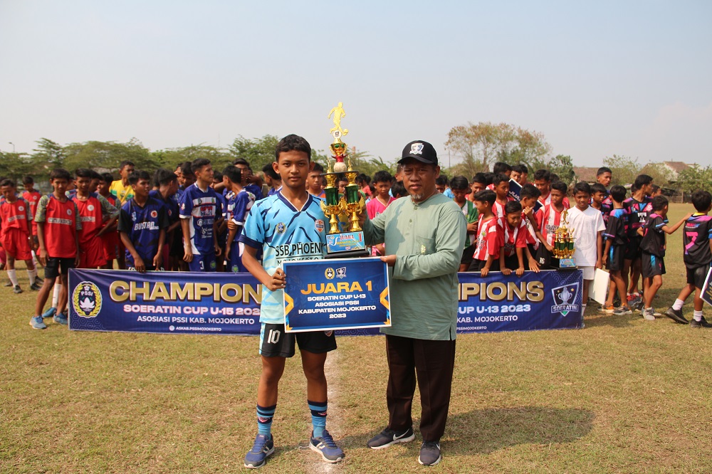 APRESIASI: Ketua Askab PSSI Mojokerto KH. Fathur Rohman menyerahkan piala kepada juara Piala Soeratin U-13 dan U-15.