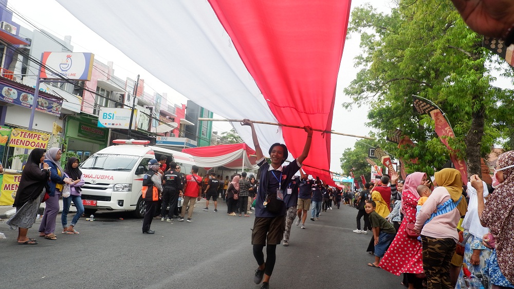 CATATAN SEJARAH: Peserta Gerak Jalan Mojokerto-Surabaya (GMS) mengarak bendera merah putih sepanjang 178 meter.