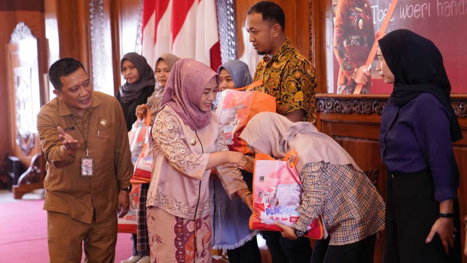 FASILITAS: Wali Kota Mojokerto Ika Puspitasari didampingi Kepala Dikbud Kota Mojokerto Amin Wachid saat menyalurkan bantuan seragam, tas, dan sepatu gratis kepada perwakilan orang tua siswa.