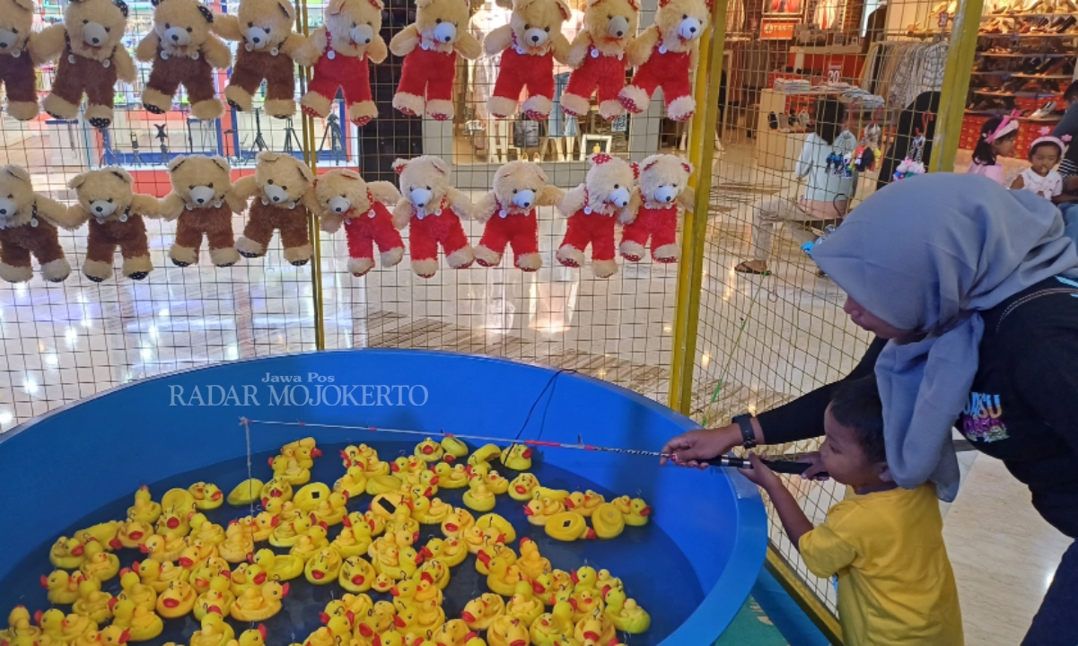 SENANG: Ibu dan anak pengunjung Sunrise Mall Mojokerto sedang memainkan mini games Cathing Duck di Grand Atrium Sunrise mall Mojokerto.
