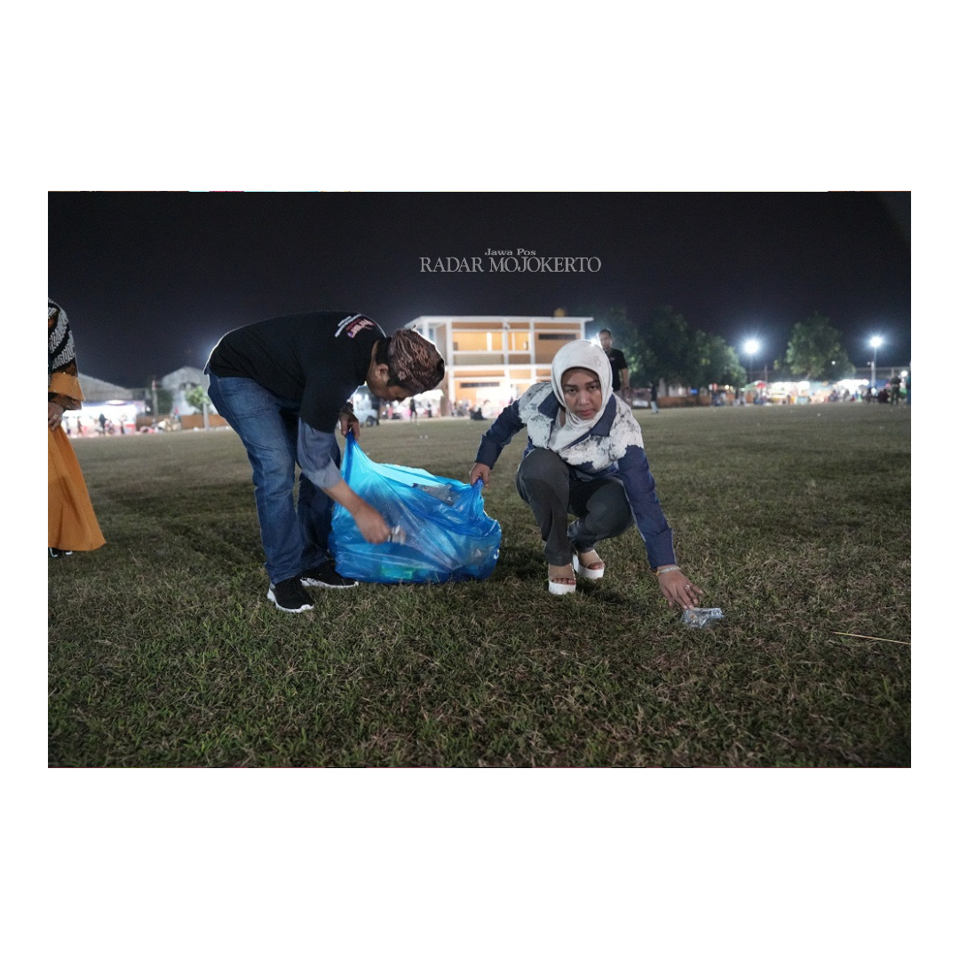 JAGA KEBERSIHAN: Wali Kota Mojokerto Ika Puspitasari bersama suami, Supriyadi Karima Saiful membersihkan sampah usai kegiatan Pertura di Lapangan Panggreman, Kecamatan Kranggan.