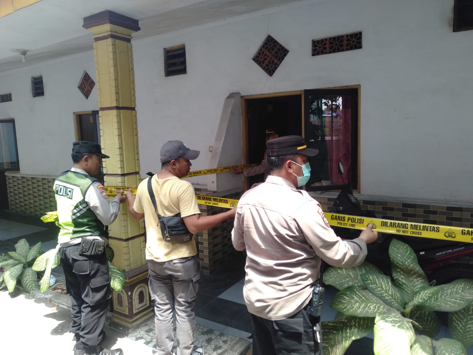 POLICE LINE: Petugas memasang garis polisi di salah satu kamar Hotel Wonokerto, Desa Sekargadung, Kecamatan Pungging, Selasa (21/11).