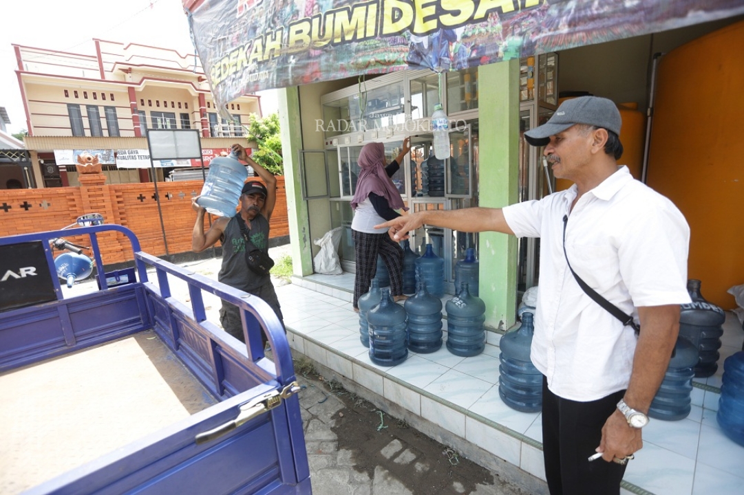 BERPENGARUH: Kepala Desa Randegan Gatot Dwitanto menilik proses isi ulang air minum yang kini dikelola BUMDes setempat.