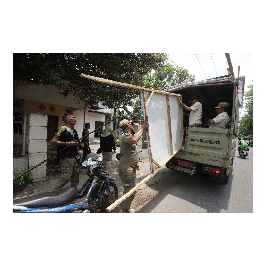 TEGAS: Bawaslu bersama Satpol PP menertibkan baliho caleg yang terpasang di pinggir jalan di Kelurahan Kedundung, Kecamatan Magersari, kemarin.
