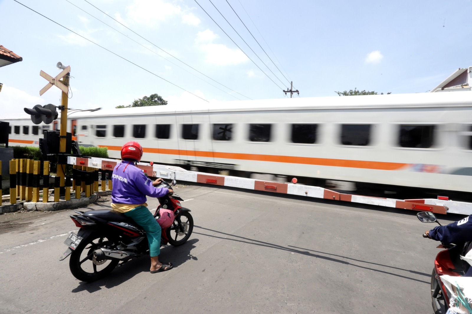 PADAT: Pengendara motor menunggu Kereta Api (KA) jarak jauh yang melintasi jalur ganda di perlintasan Jalan Pahlawan kemarin.