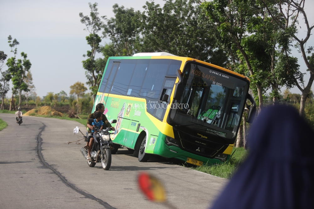 TERJEREMBAB: Pengguna jalan mendapati seunit bus Trans Jatim yang terjerembab di bahu jalan di Desa/Kecamatan Dawarblandong, Kabupaten Mojokerto, Minggu (3/12) pagi.