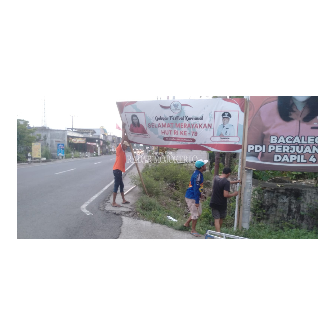 DISIKAPI: Tim pemenangan caleg secara mandiri melakukan pencopotan banner caleg yang terpampang foto Kades Sawo, Kecamatan Jetis di pintu masuk gapura desa usai ditegur Panwascam Jetis.
